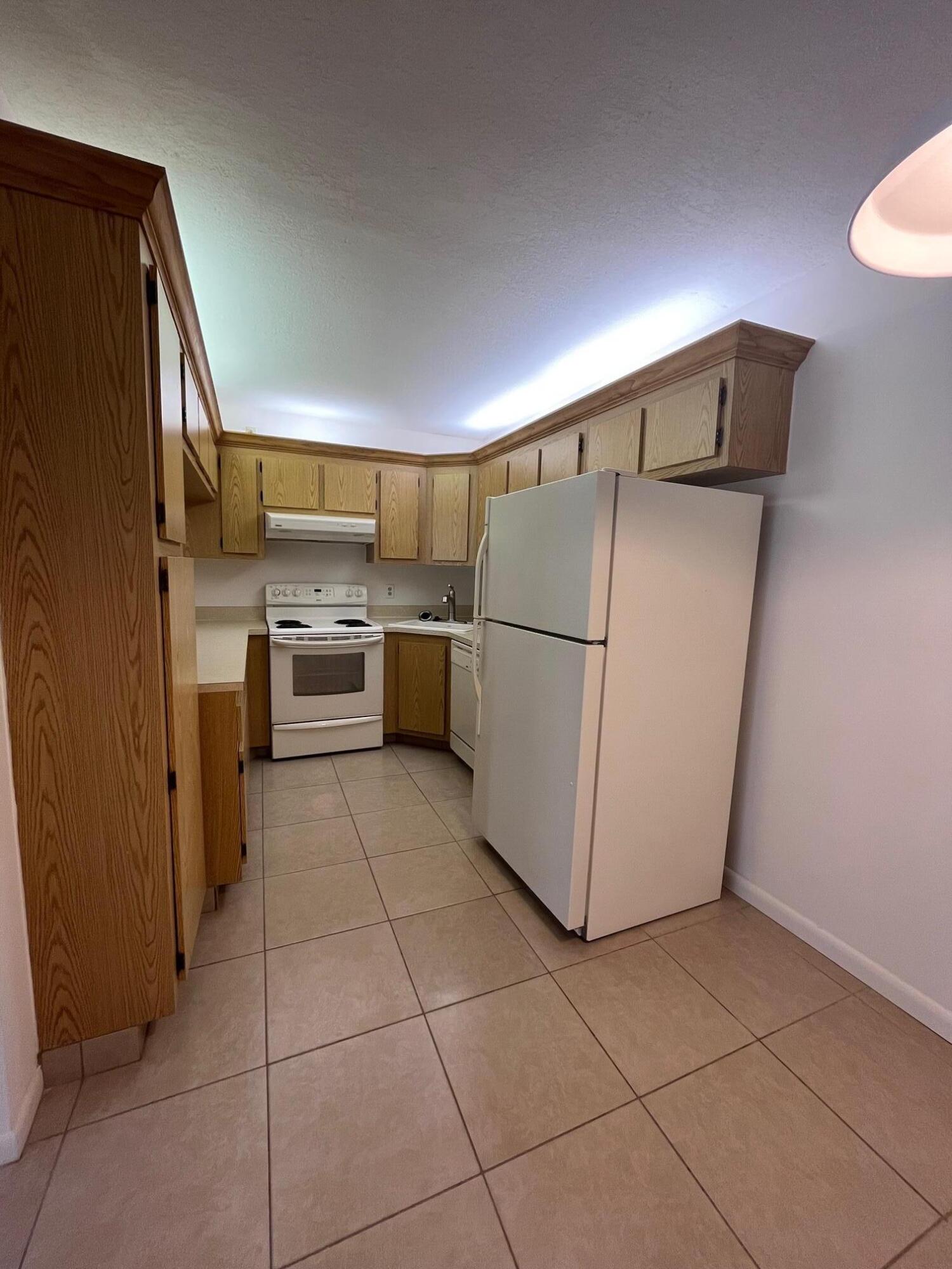 801 Sky Pine Way, Unit B1 Greenacres, FL 33415 - Photo 8 of 17 a kitchen with a refrigerator and a stove top oven