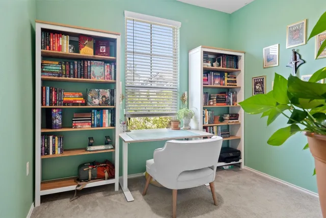 a living room with furniture and a book shelf