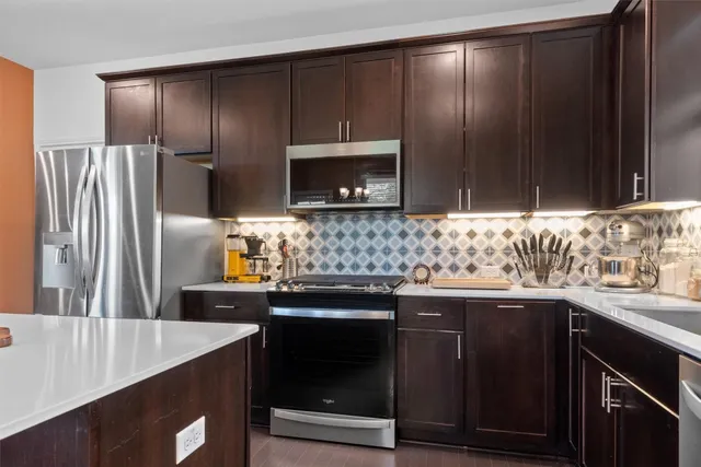 a kitchen with granite countertop wooden cabinets and stainless steel appliances