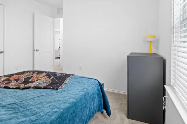 a bedroom with a bed next to a window