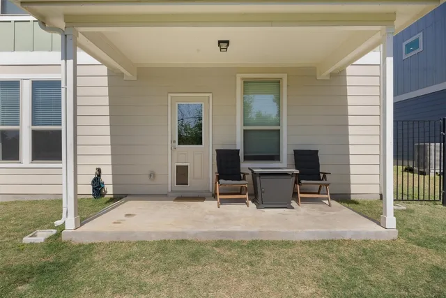 a view of a chair and table in backyard of the house