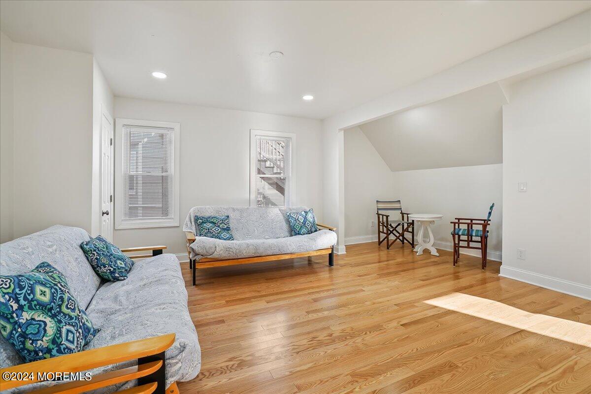 116 11th Avenue, Unit 2 Belmar, NJ 07719 - Photo 11 of 26 a living room with furniture and a dining table with wooden floor