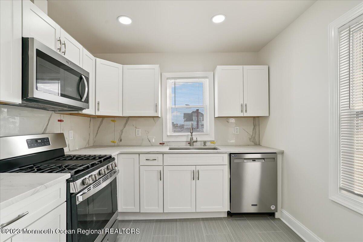 116 11th Avenue, Unit 2 Belmar, NJ 07719 - Photo 16 of 26 a kitchen with white cabinets stainless steel appliances and window