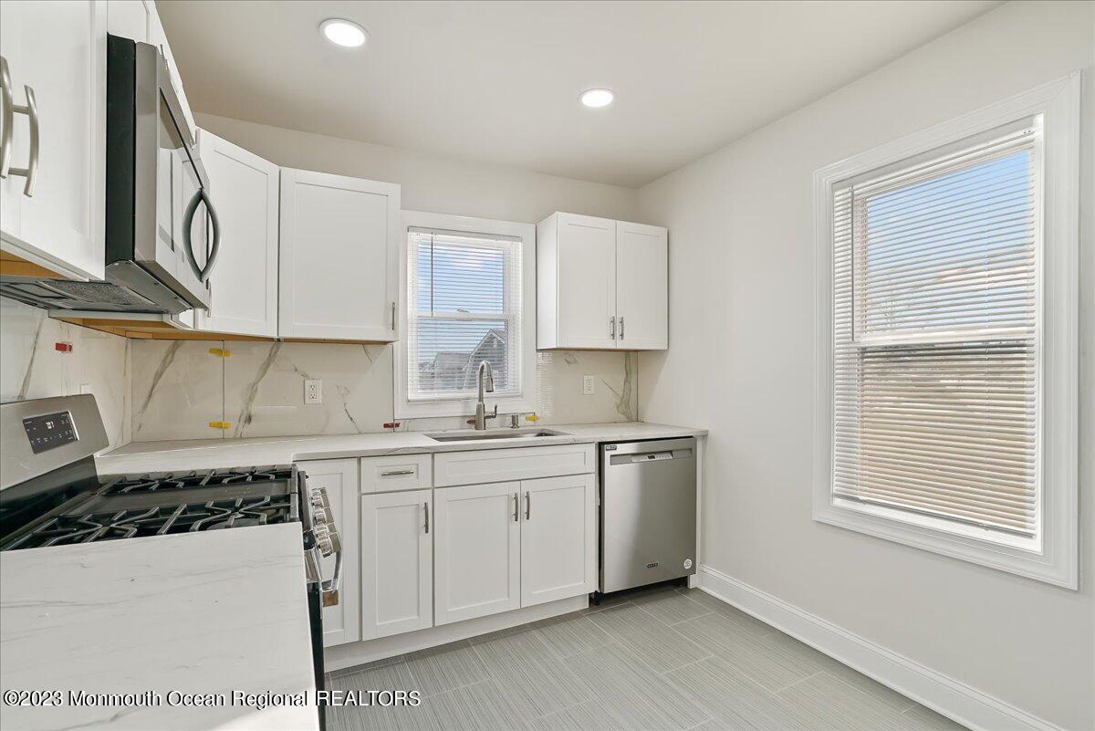 116 11th Avenue, Unit 2 Belmar, NJ 07719 - Photo 17 of 26 a kitchen with stainless steel appliances a sink a stove a refrigerator and cabinets