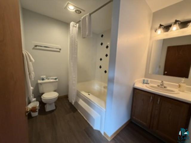 6266 Giants Ridge Road Biwabik, MN 55705 - Photo 25 of 30 Bathroom featuring a built-in bathtub with shower, a vanity with an integrated sink, a wall-mounted mirror, and wood-finish flooring
