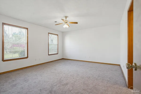 an empty room with closet and windows