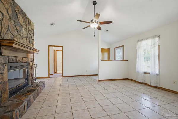 a view of an empty room with a fireplace and a window