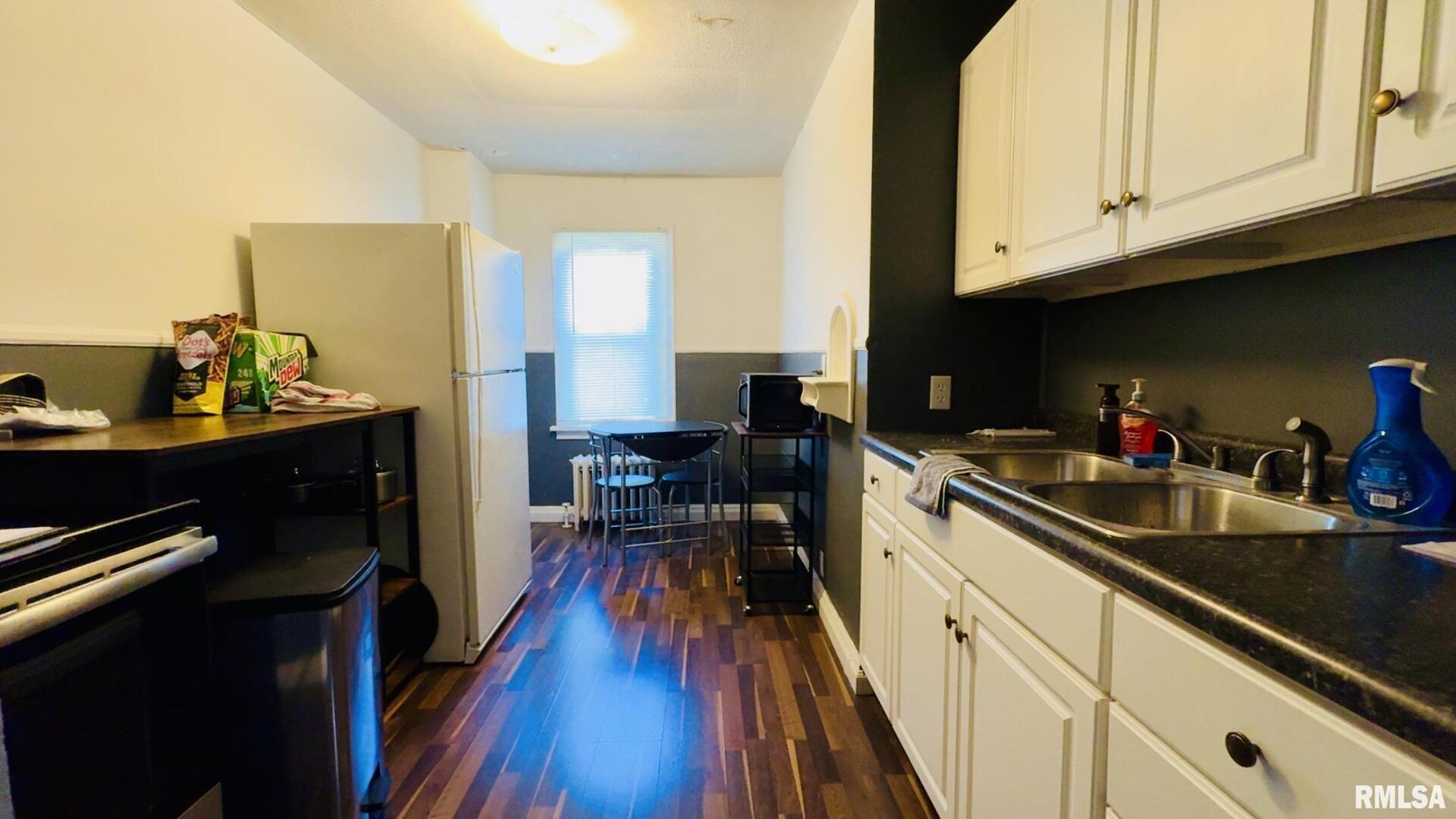 419 East Church Street Benton, IL 62812 - Photo 12 of 16 a kitchen with sink cabinets and a wooden floor