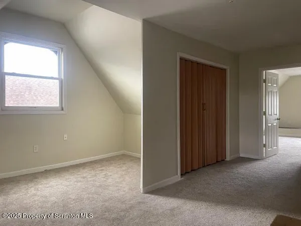 an empty room with windows and closet