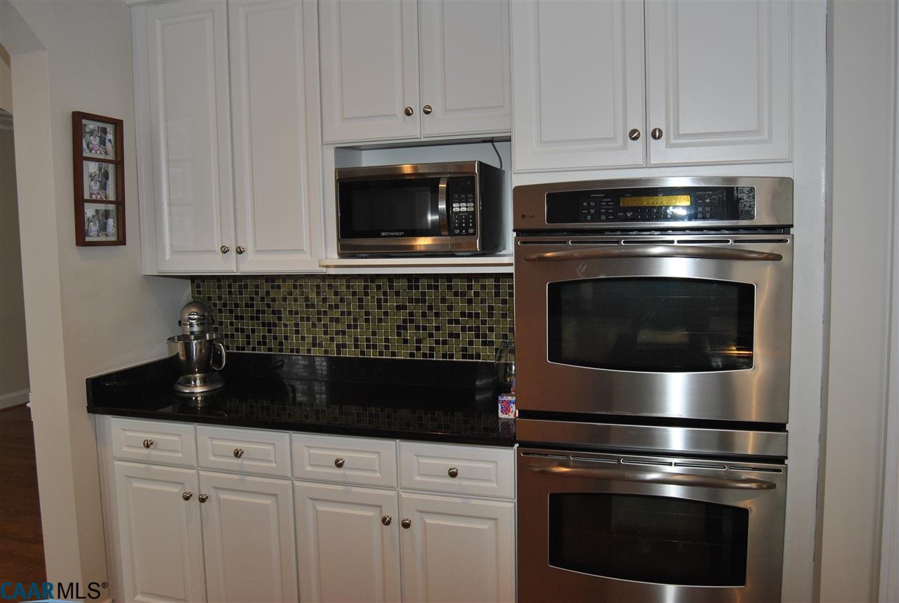 1860 Rhett Court Charlottesville, VA 22903 - Photo 17 of 39 a kitchen with white cabinets and black appliances