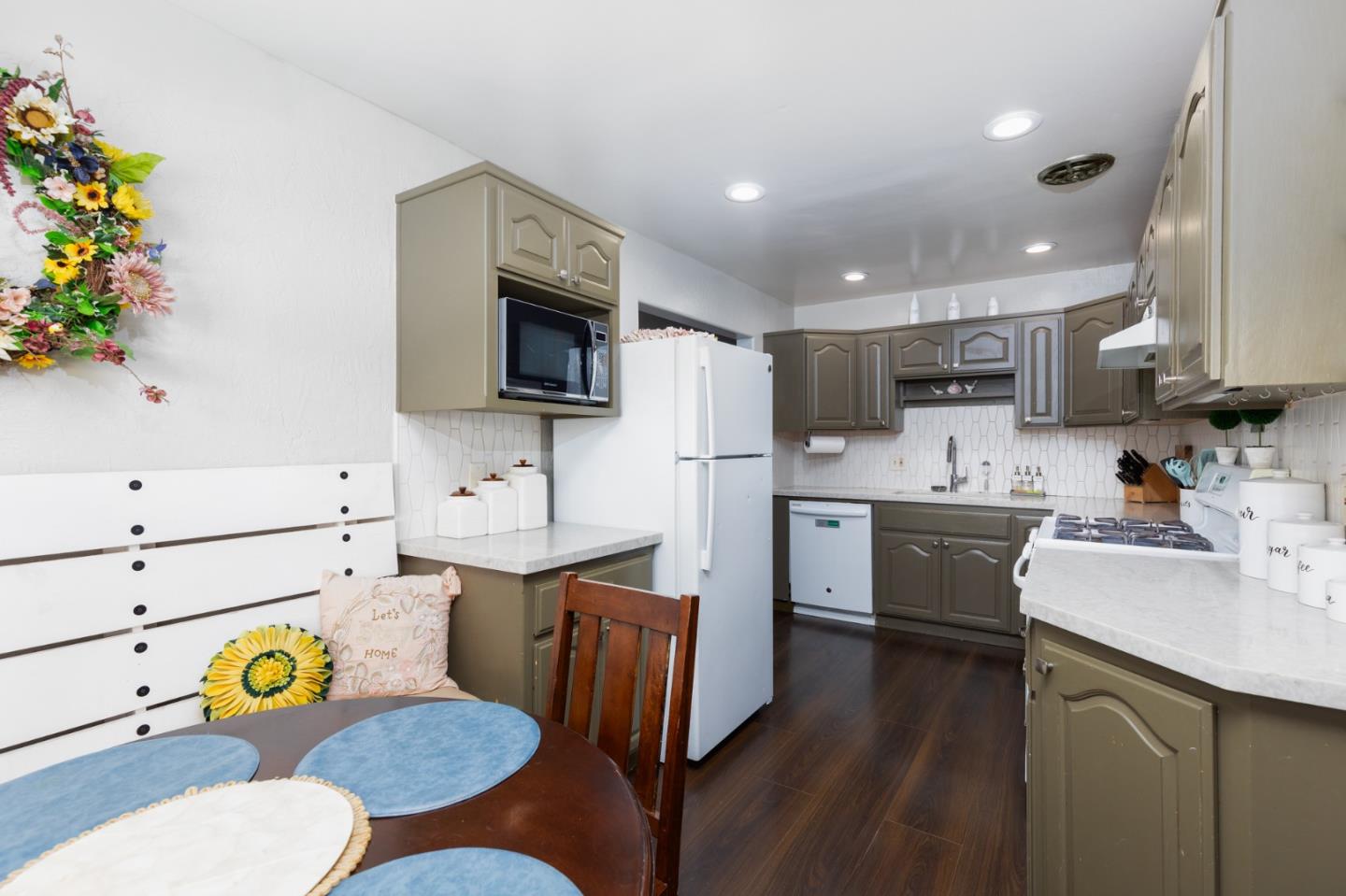 1446 Sharp Avenue Campbell, CA 95008 - Photo 4 of 22 a kitchen with stainless steel appliances kitchen island granite countertop a sink a stove a dining table and chairs