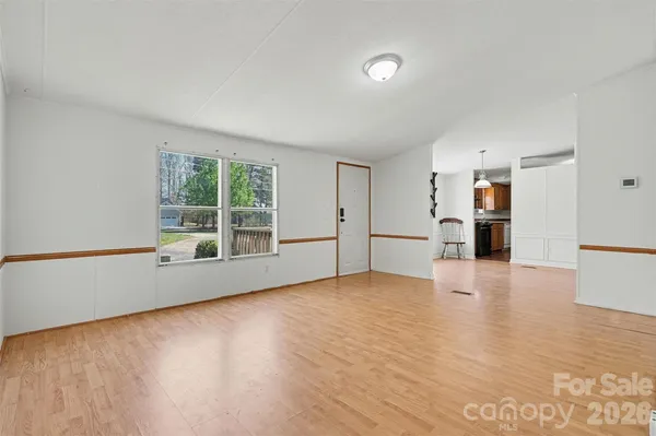 a view of empty room with wooden floor and windows