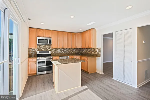 a kitchen with a refrigerator and a stove top oven
