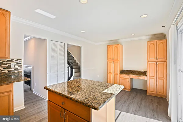 a view of kitchen with granite countertop cabinets and wooden floor