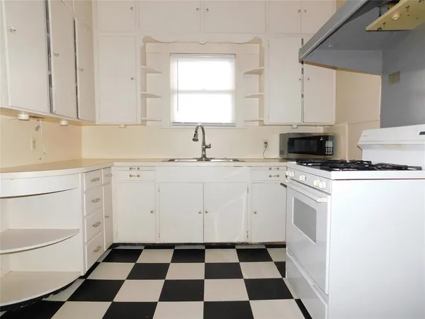 a kitchen with a stove a sink and a window