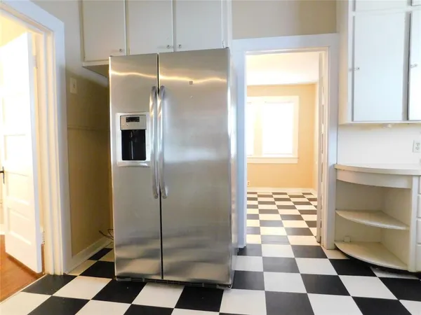 a kitchen with a checkered floor and a refrigerator