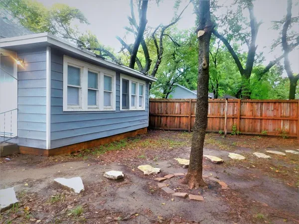 a backyard of a house with large trees and outdoor space