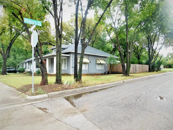 a view of a house with backyard and a tree