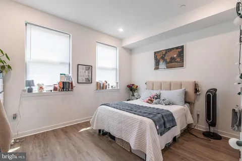 a bedroom with a bed and a large mirror next to a window