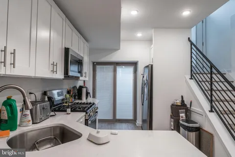 a kitchen with stainless steel appliances a sink and a refrigerator