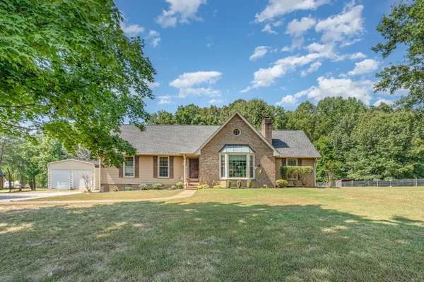 a front view of a house with yard and green space