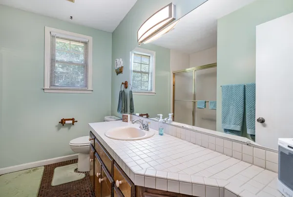 a bathroom with a sink a toilet and shower