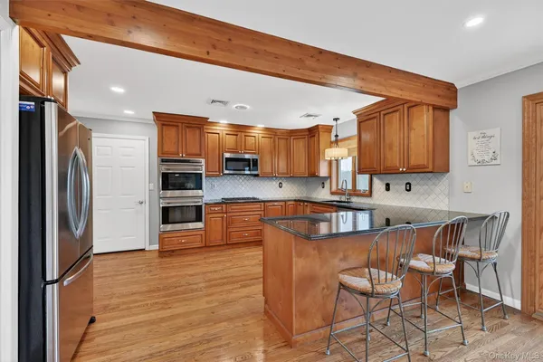 a kitchen with stainless steel appliances a refrigerator and wooden cabinets