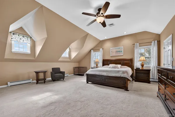 a spacious bedroom with a bed a couch and a chandelier