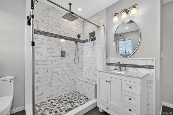 a bathroom with a sink a toilet and shower