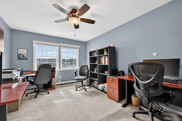 a view of a workspace with furniture and a window