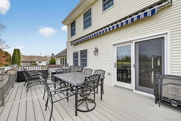 a view of a roof deck with table and chairs and wooden floor