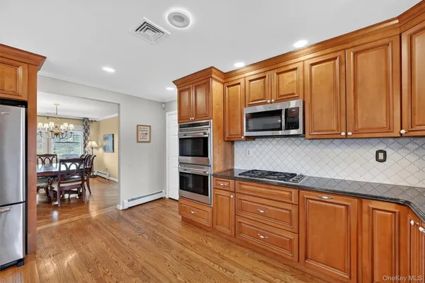 a kitchen with stainless steel appliances granite countertop a refrigerator microwave and stove top oven