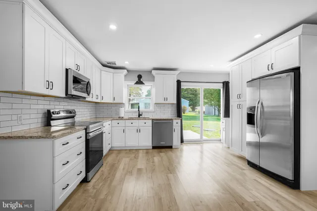 a kitchen with stainless steel appliances a refrigerator sink and microwave
