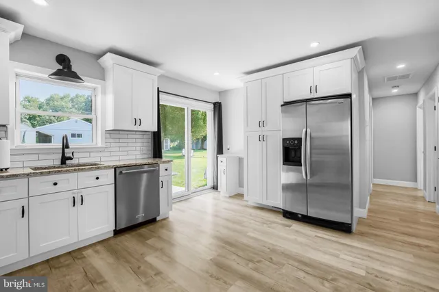 a kitchen with granite countertop a refrigerator and a sink