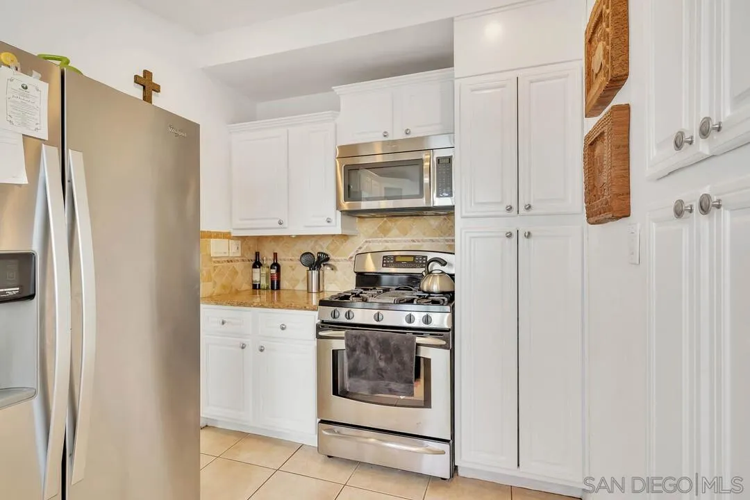 796 Neptune Avenue Encinitas, CA 92024 - Photo 32 of 49 a kitchen with stainless steel appliances granite countertop white cabinets and a refrigerator
