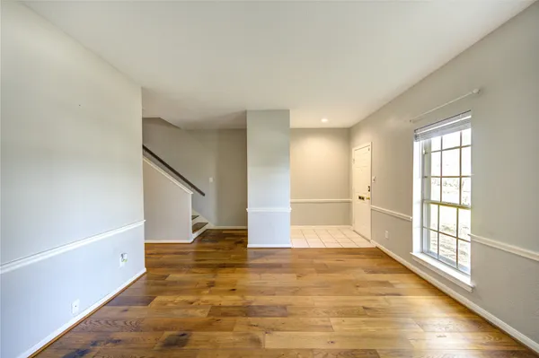 a view of empty room with wooden floor and window