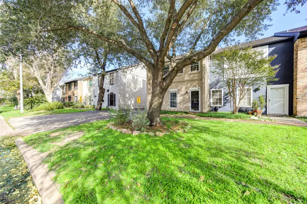 a front view of a house with yard and green space