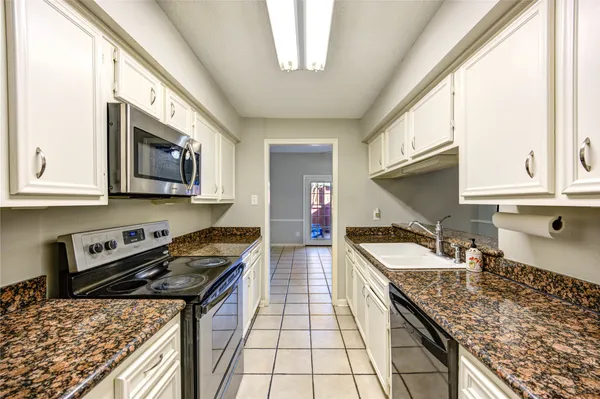 a kitchen with stainless steel appliances granite countertop a sink stove and microwave