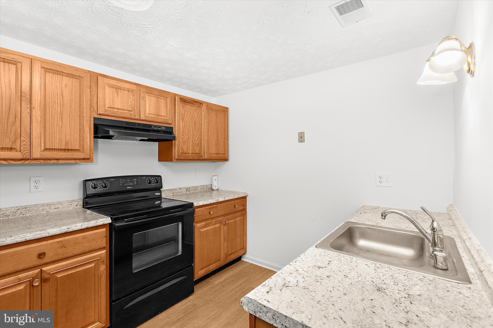 5920 Watch Chain Way, Unit 5102 Columbia, MD 21044 - Photo 15 of 29 a kitchen with granite countertop a sink a stove and cabinets