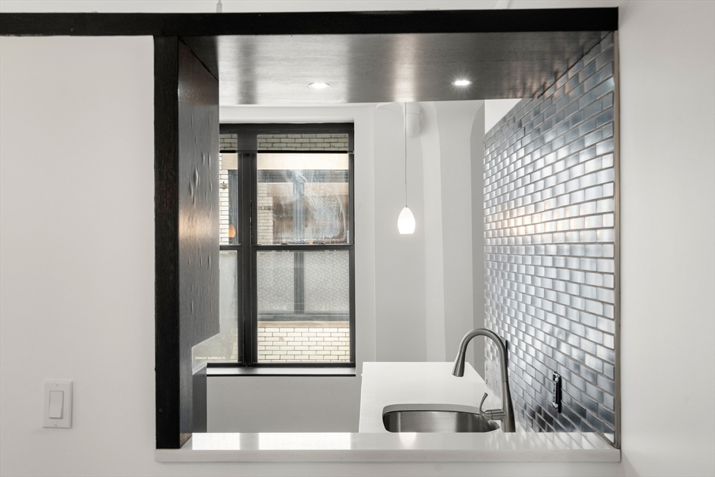 453 Washington Street, Unit 11B Boston, MA 02111 - Photo 12 of 30 a bathroom with a sink and mirror