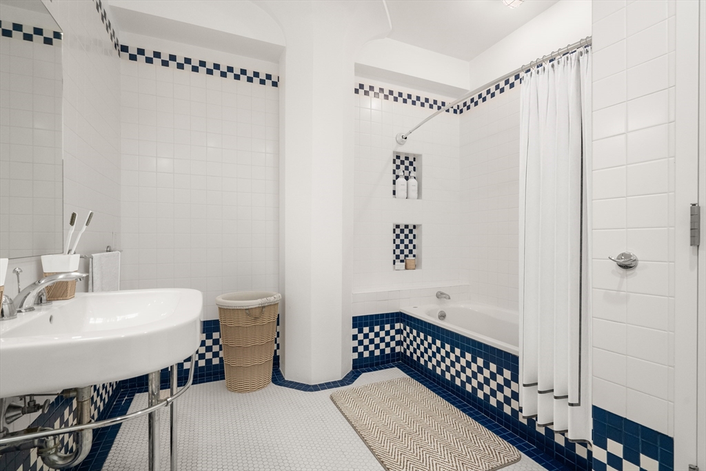 453 Washington Street, Unit 11B Boston, MA 02111 - Photo 19 of 30 a bathroom with a sink a toilet and a mirror