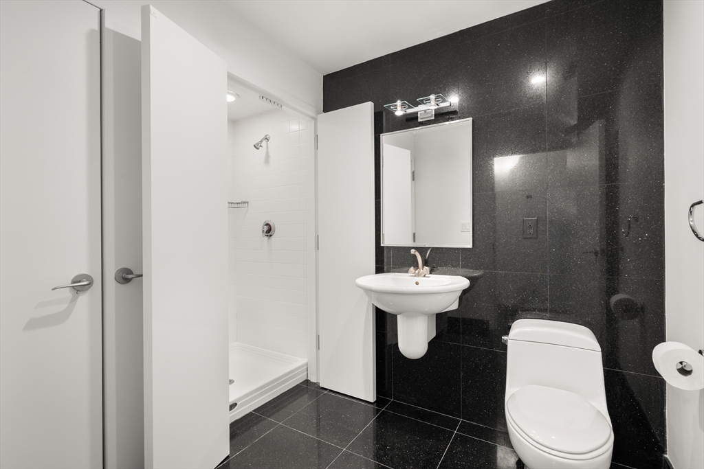 453 Washington Street, Unit 11B Boston, MA 02111 - Photo 24 of 30 a bathroom with a sink toilet and a mirror