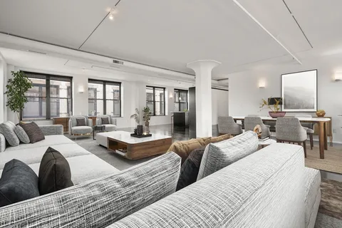 a large bedroom with three beds and large windows