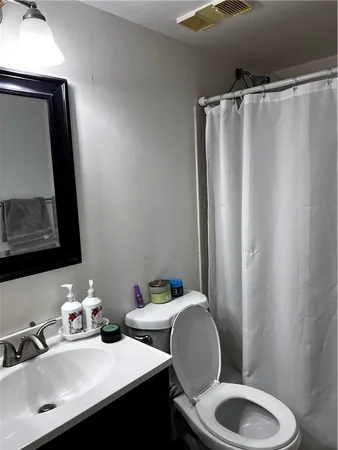 a bathroom with a sink mirror and toilet