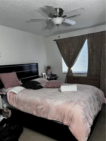 a bedroom with a bed and a ceiling fan