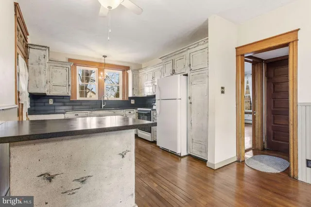 a kitchen with granite countertop a refrigerator and a sink