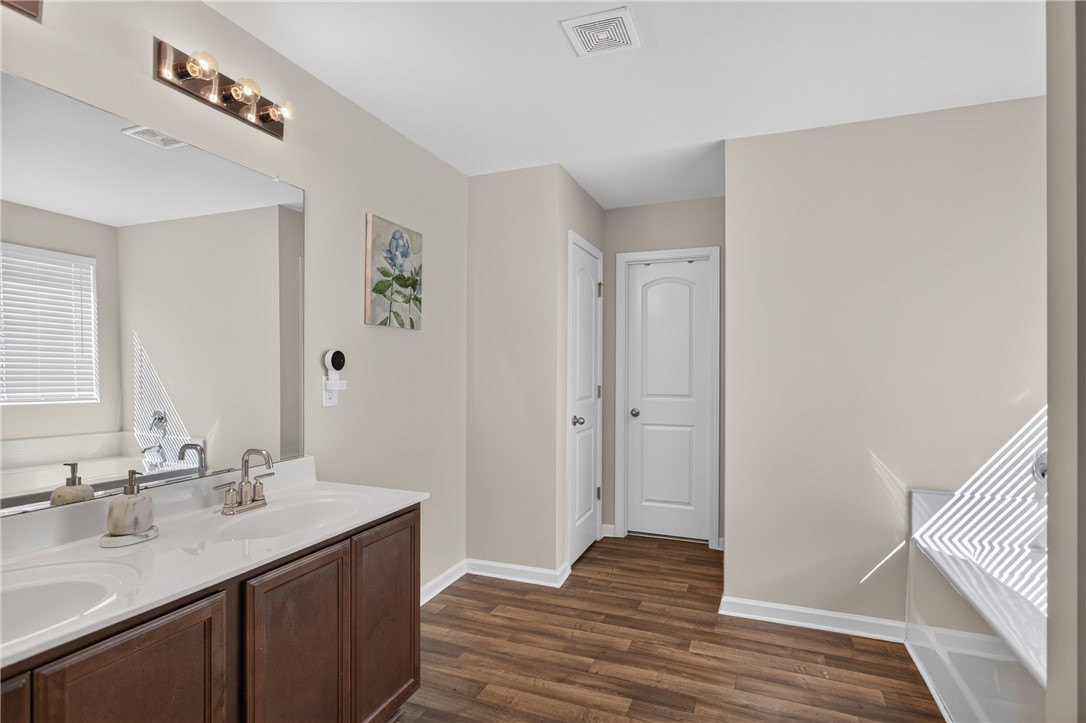 1081 Edenbrooke Circle Anderson, SC 29621 - Photo 27 of 46 Double vanity sinks and rich wood-toned flooring complement this practical bathroom space.