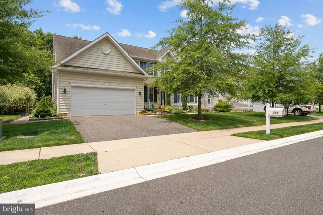 a front view of a house with a yard and trees