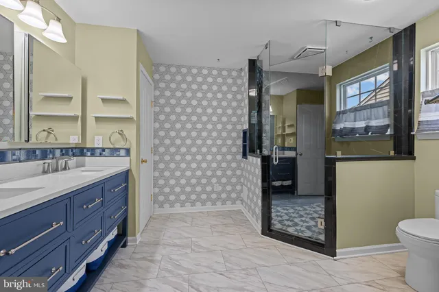 a bathroom with a granite countertop sink a toilet and shower