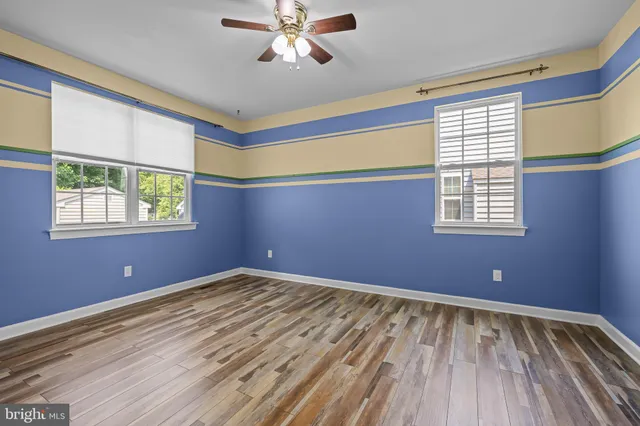 a view of empty room with window and wooden floor